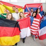 Personas mostrando las banderas de sus paises Requisitos para estudiar en el exterior: mantener una conversación en inglés